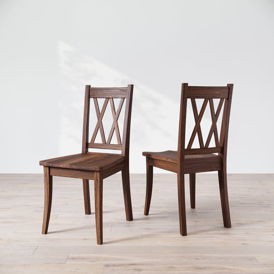 Two wooden dining chairs with a 'Double X Back' design, placed against a neutral background.