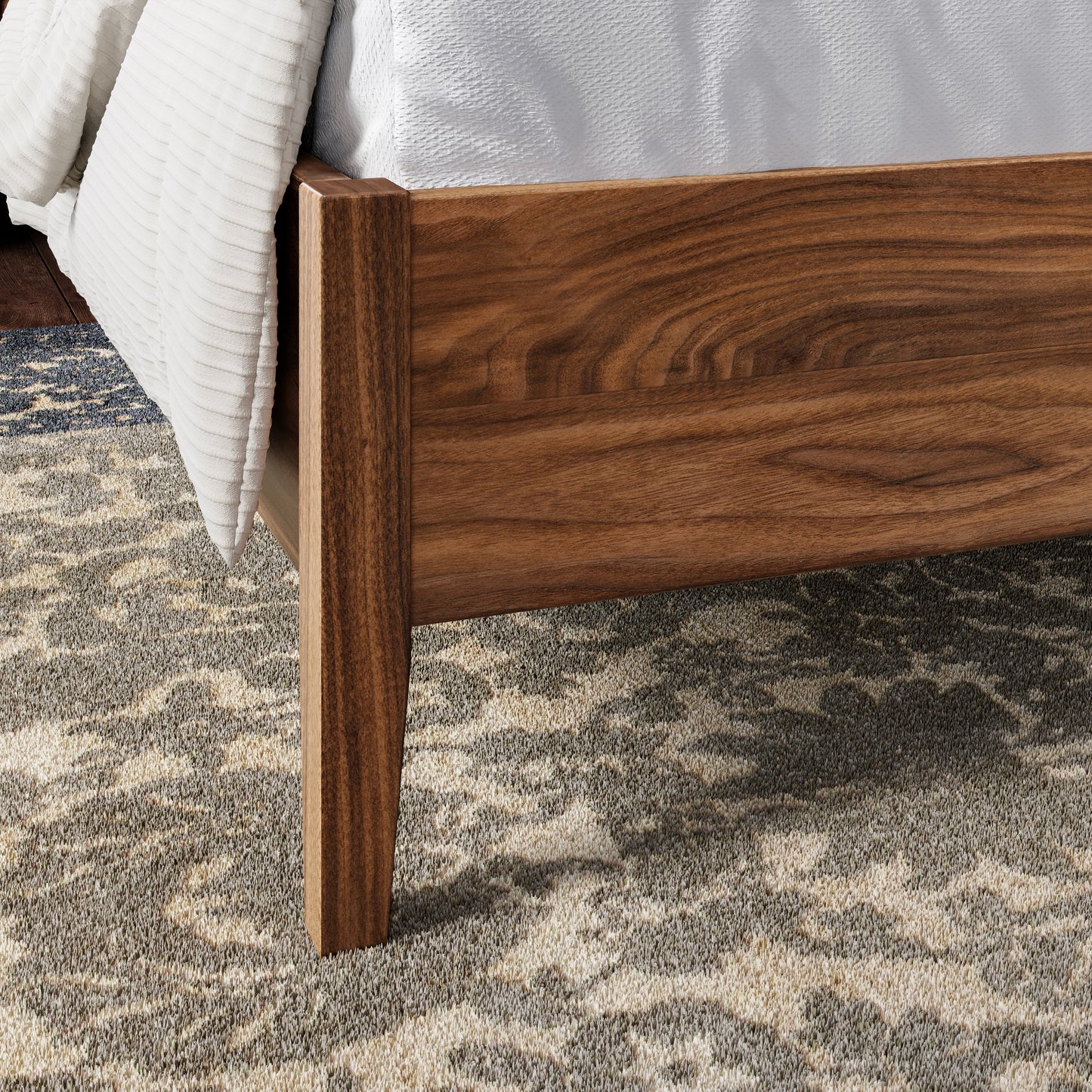Close up of a walnut bedframe leg in an upscale, well lit bedroom
