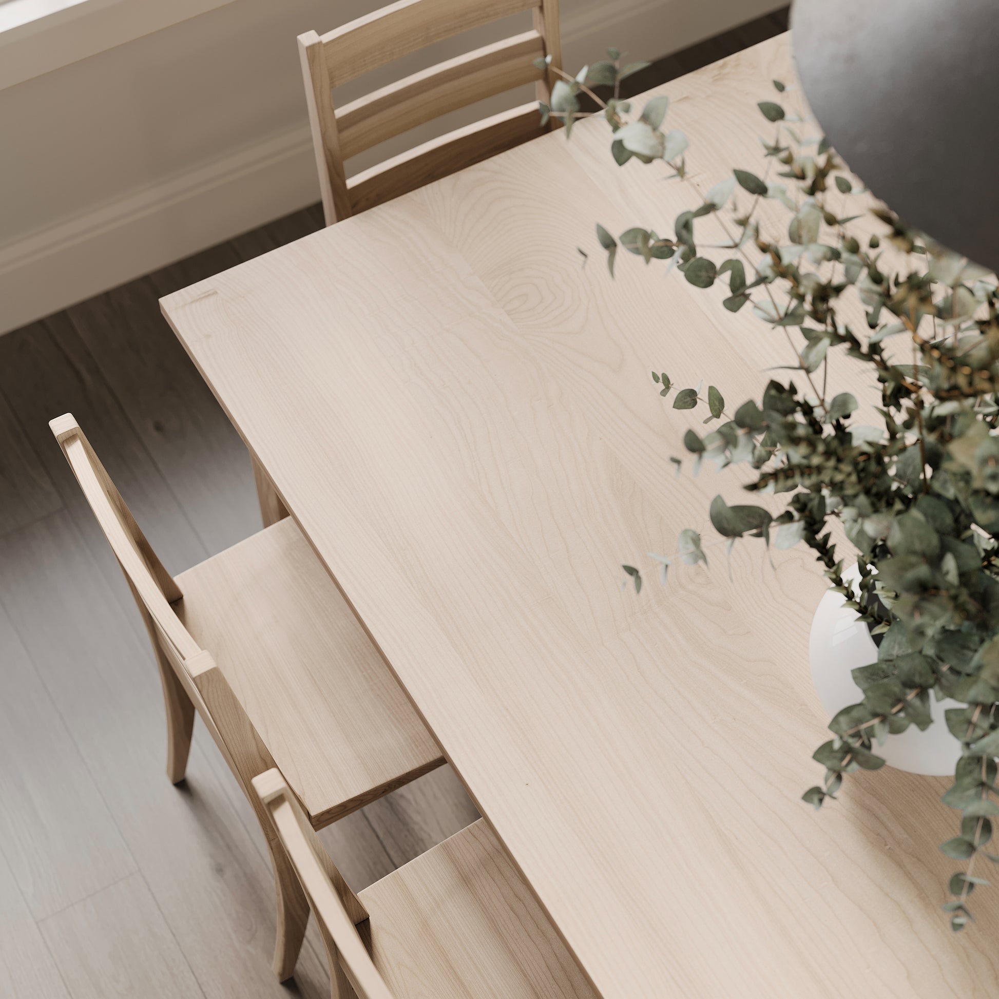 Top down view of a maple parson style dining table in a brightly lit dining room