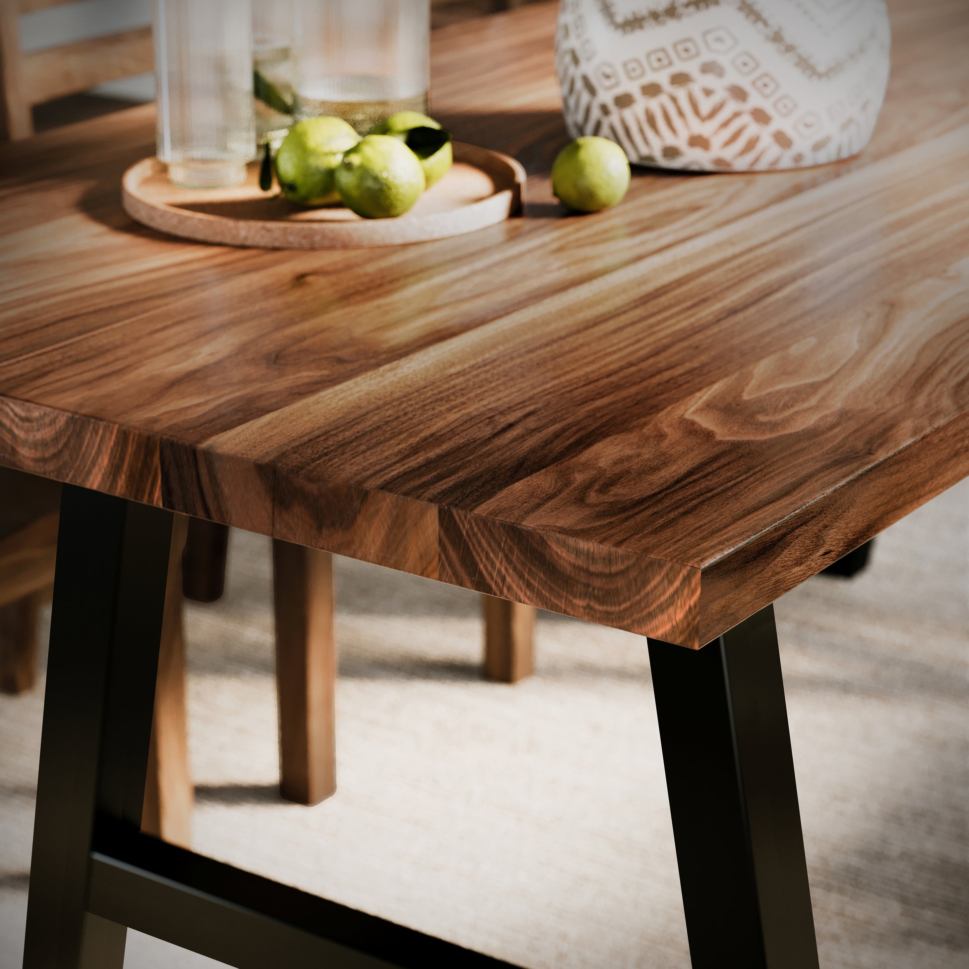 close up image of a walnut dining table with black metal legs