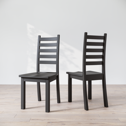 Two black wooden dining chairs with a commercial grade finish, displayed against a white background.