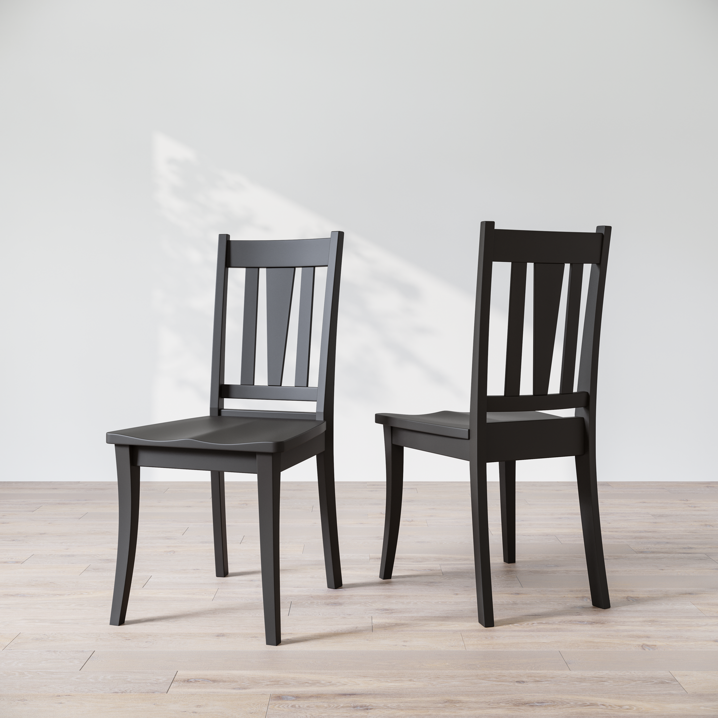 Two black wooden dining chairs with a brown finish, showcasing a slatted backrest and a solid seat, placed against a white background.