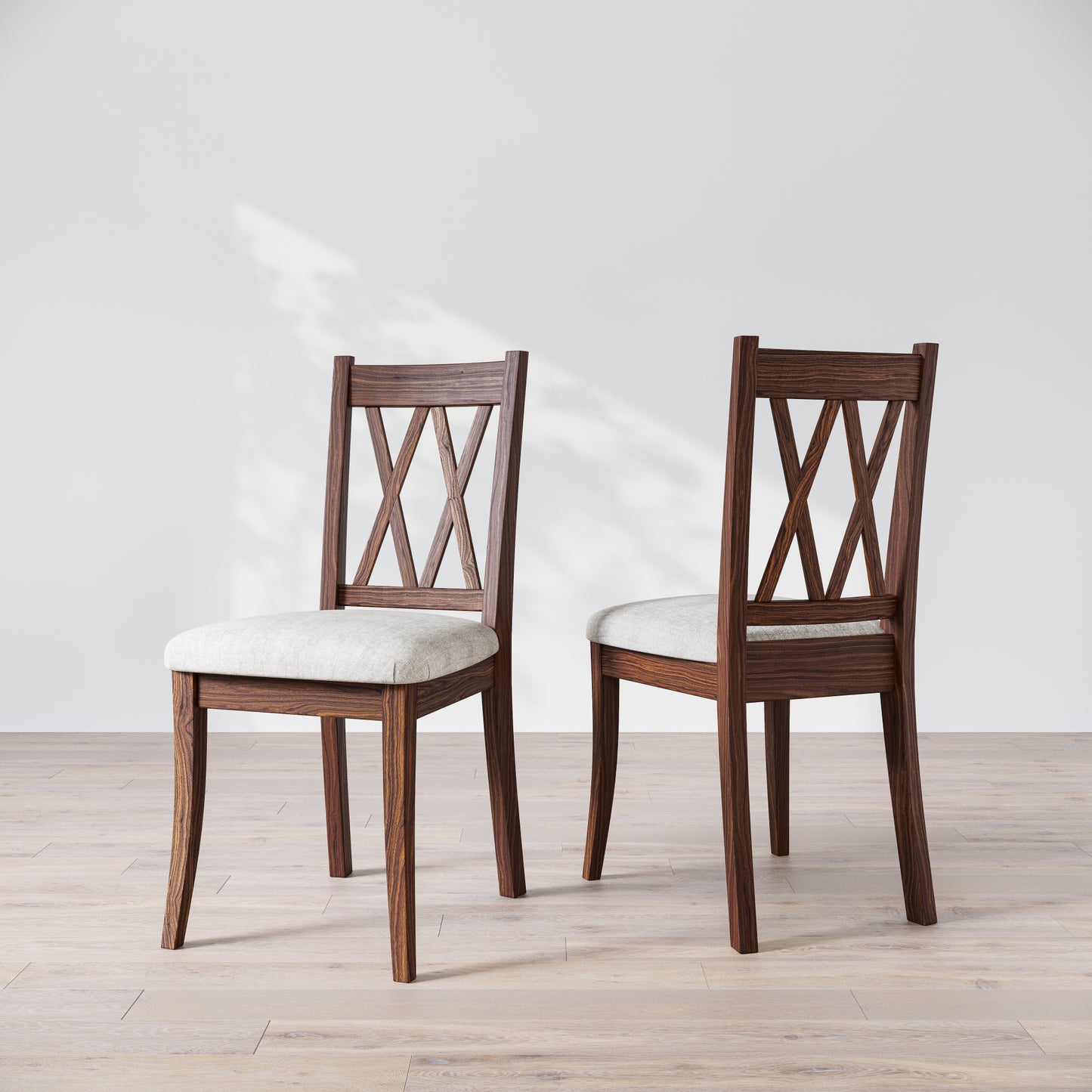 Two wooden dining chairs with a 'Double X Back' design and beige upholstered seats, placed against a neutral background.