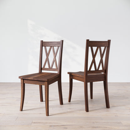 Two wooden dining chairs with a 'Double X Back' design, placed against a neutral background.
