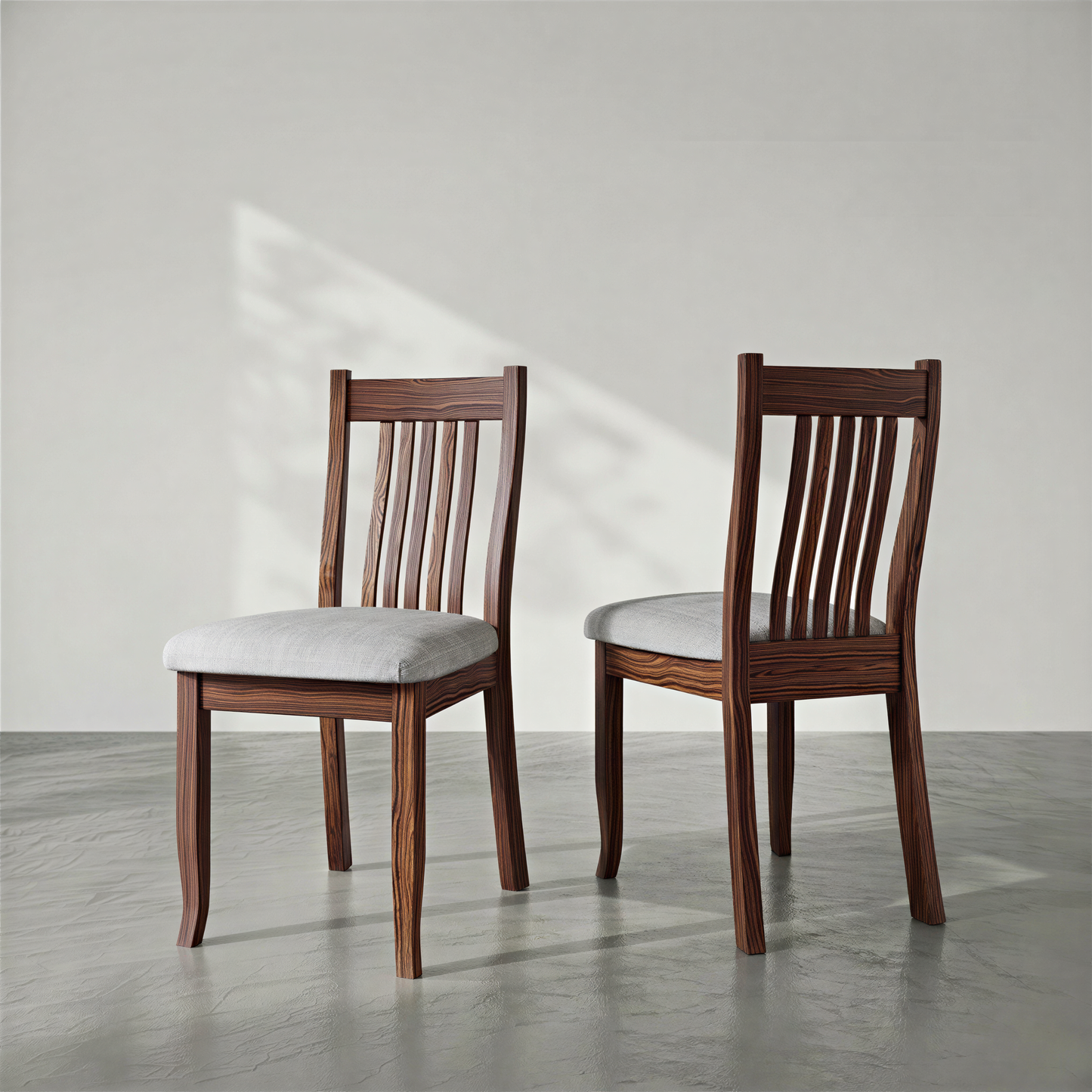 Two wooden chairs with white cushions on a light gray floor and background