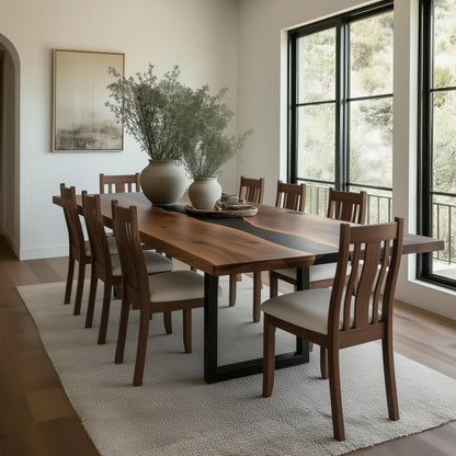 Dining room with a wooden table and chairs near large windows.