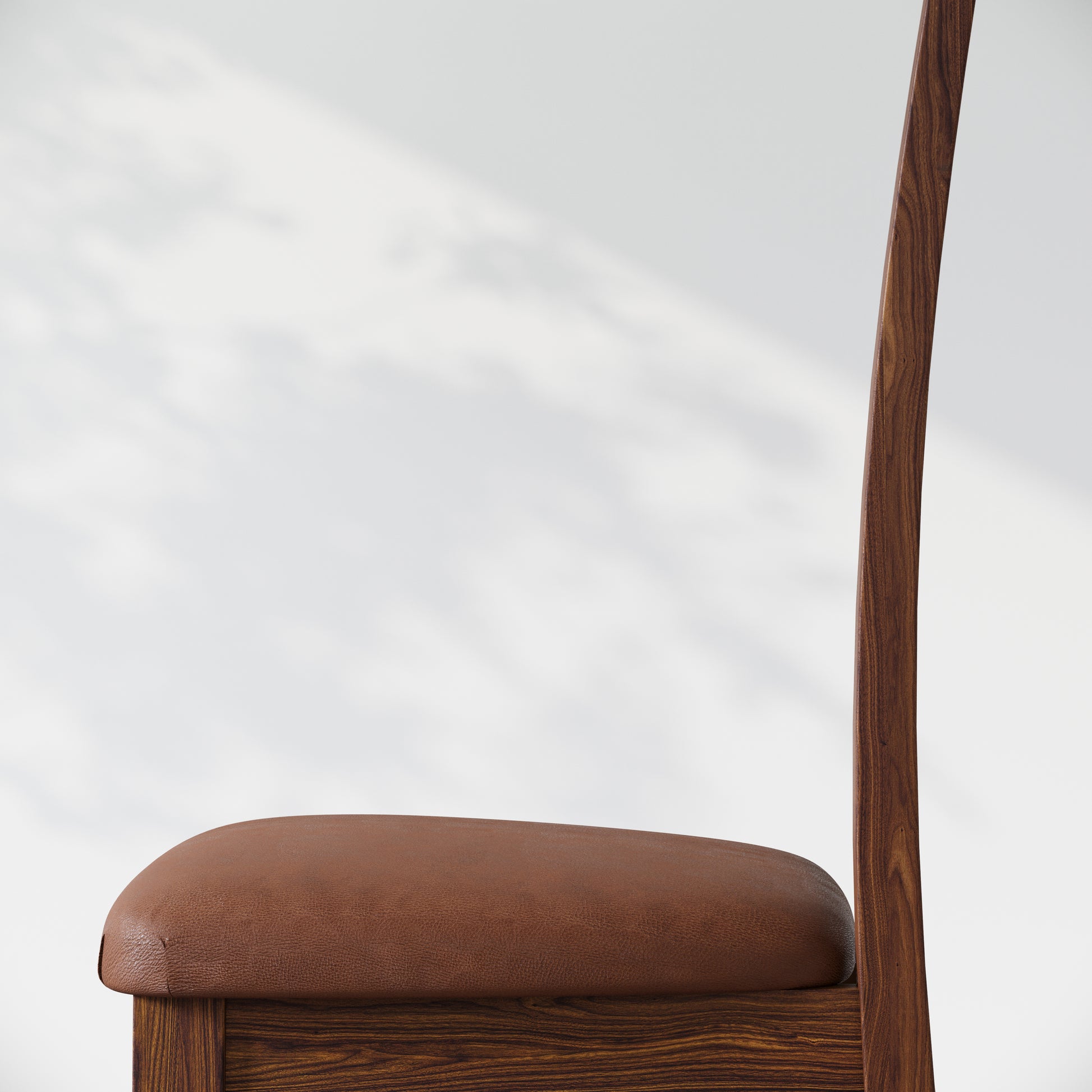 Side view of an upholstered walnut dining chair, against a white background.