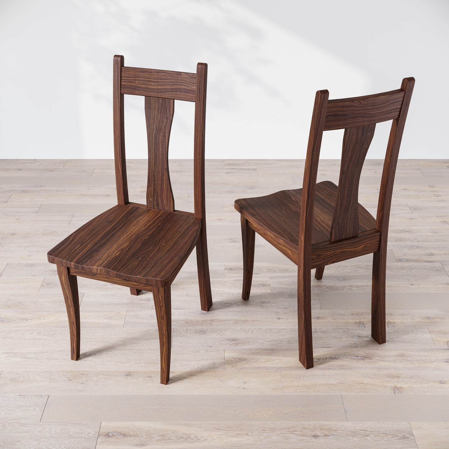 Top down view of two walnut wooden dining chairs with, one in front of the other, against a white background.