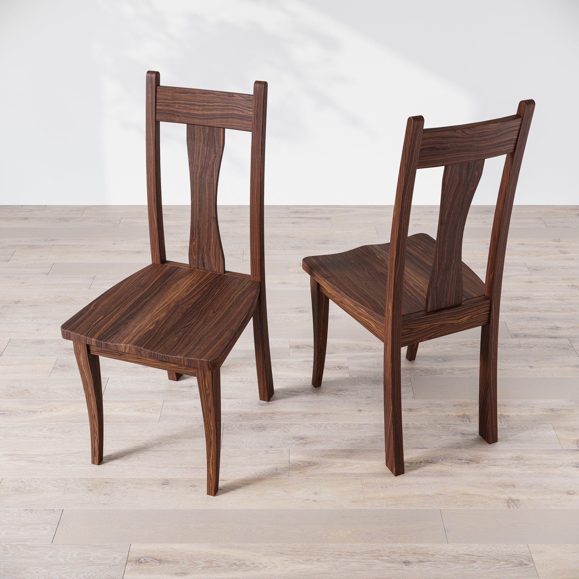 Top down view of two walnut wooden dining chairs with, one in front of the other, against a white background.
