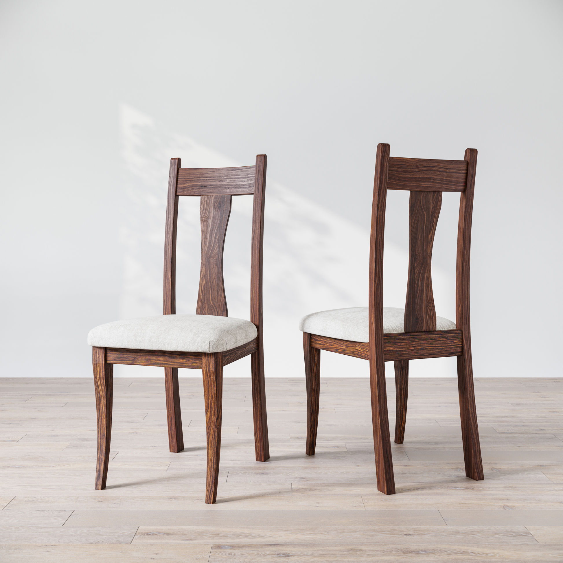 Two wooden dining chairs with upholstered seats, one in front of the other, against a white background.