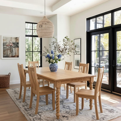 Dining room with wooden table and chairs, large windows, and decorative elements.