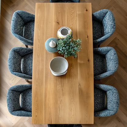 Wooden dining table with blue chairs on a wooden floor