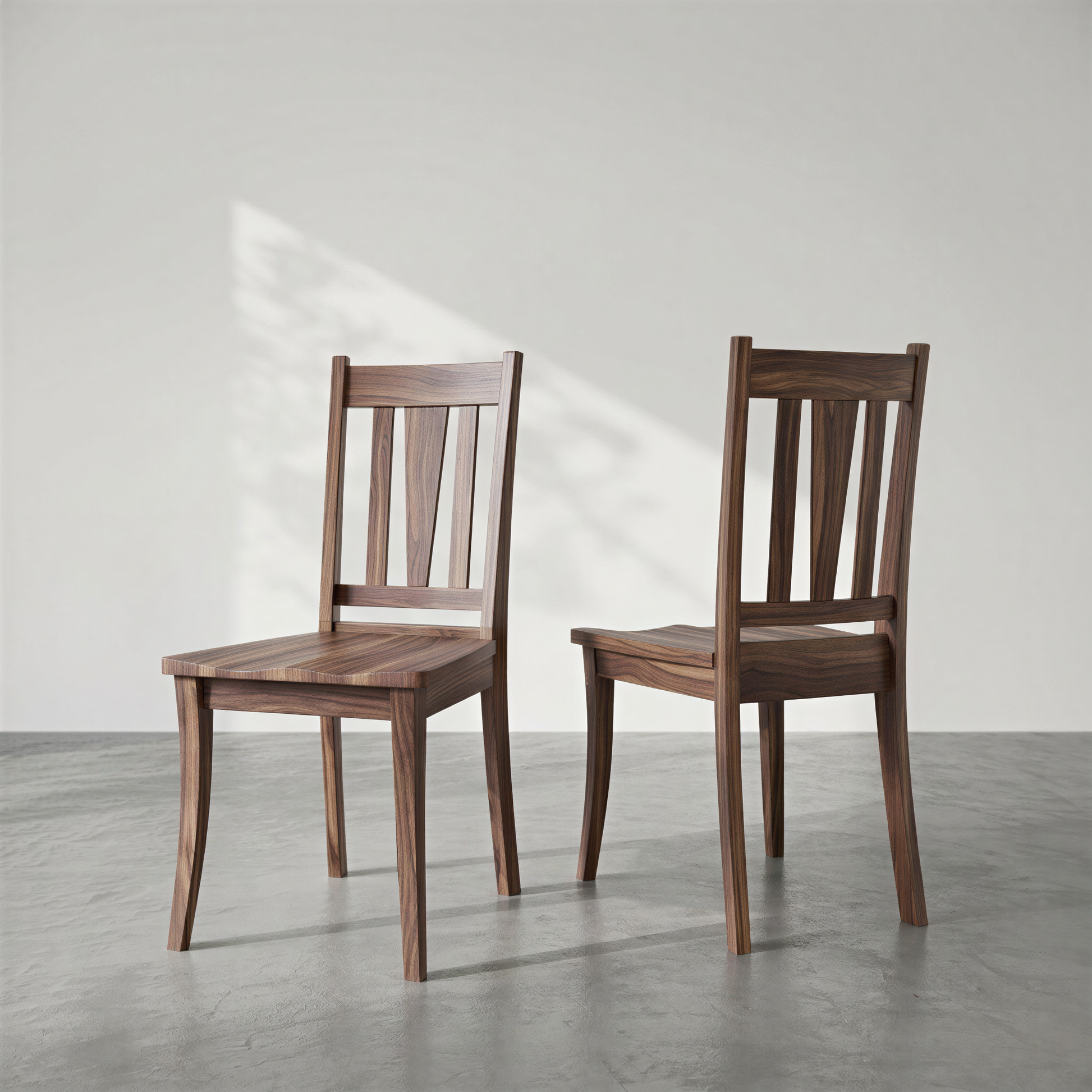 Two wooden chairs on a gray floor with a white wall background