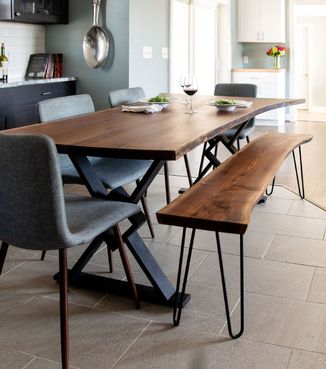 A live edge walnut dining table and matching bench in a small dining room