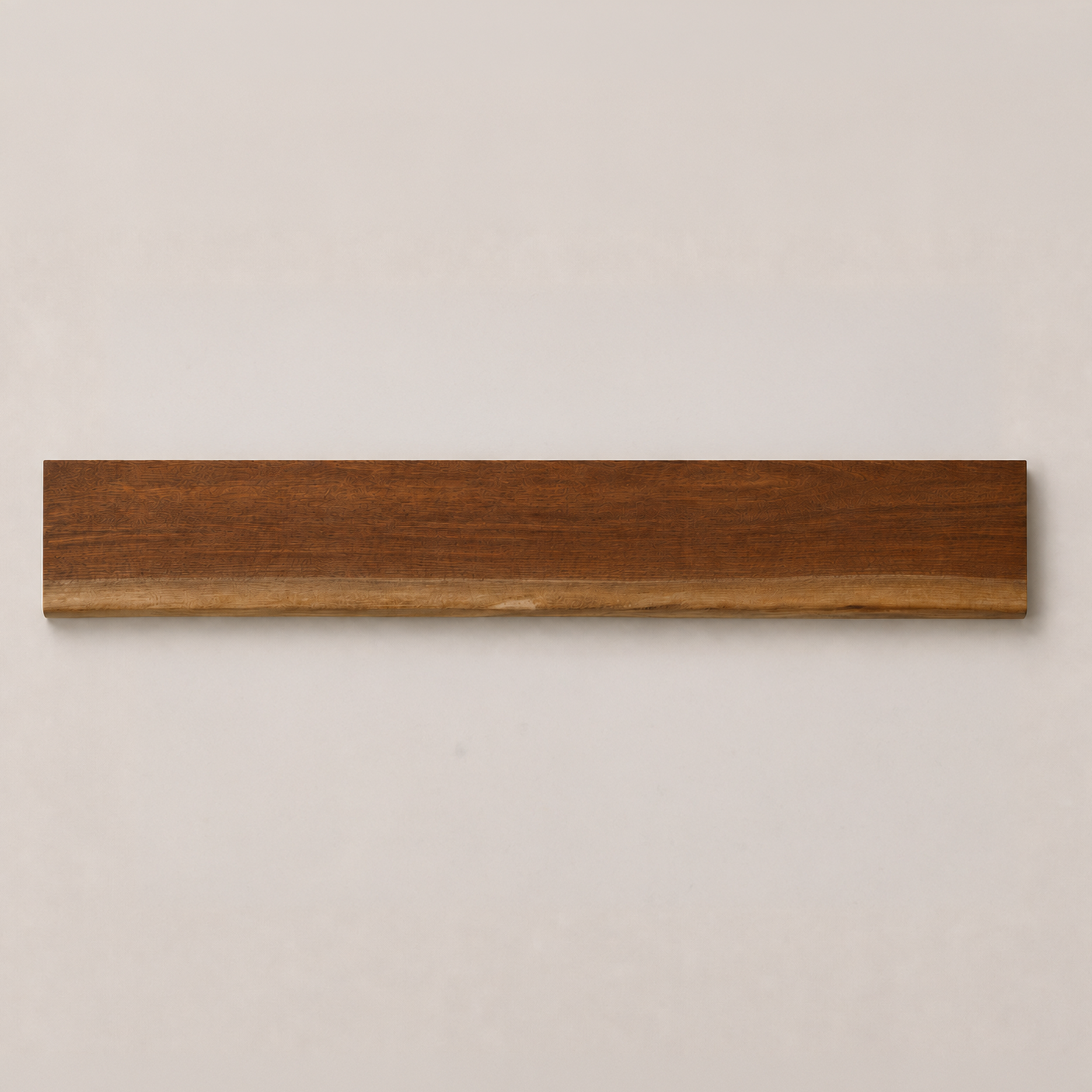 A long, narrow rectangular wooden board with a natural live edge, shown horizontally against a plain light beige background.