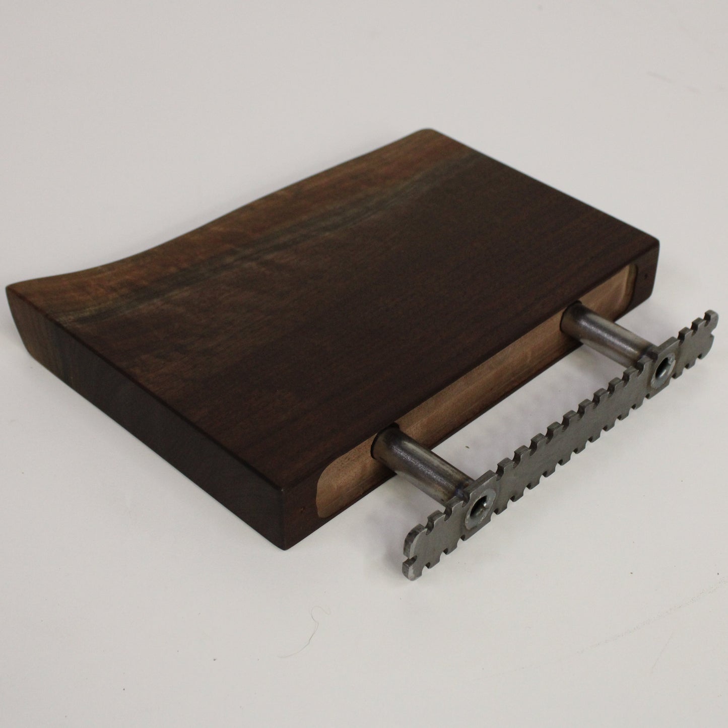 Wooden shelf with metal brackets on a light gray background