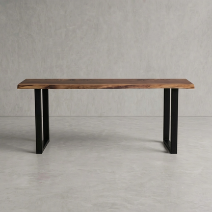 A rectangular wooden table with a live-edge natural wood top and black metal legs, shown against a neutral gray concrete-textured background.