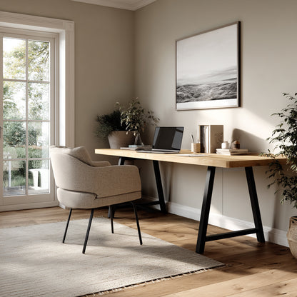 Modern home office with a wooden desk, chair, and framed artwork.