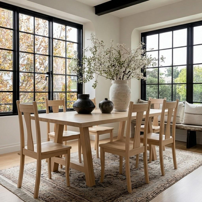 Dining room with wooden table and chairs, large windows, and decorative elements.