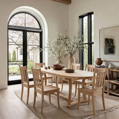 Dining room with wooden table and chairs, large windows, and decorative elements.