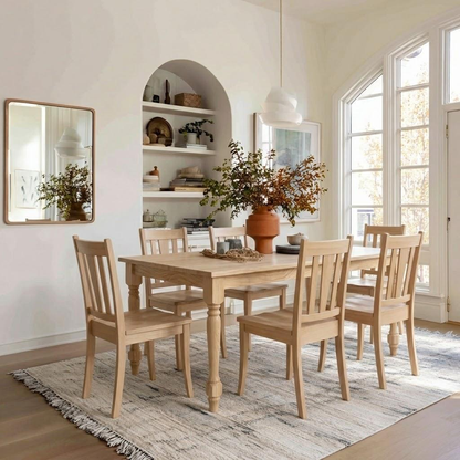 Dining room with wooden table and chairs, large mirror, and window light.
