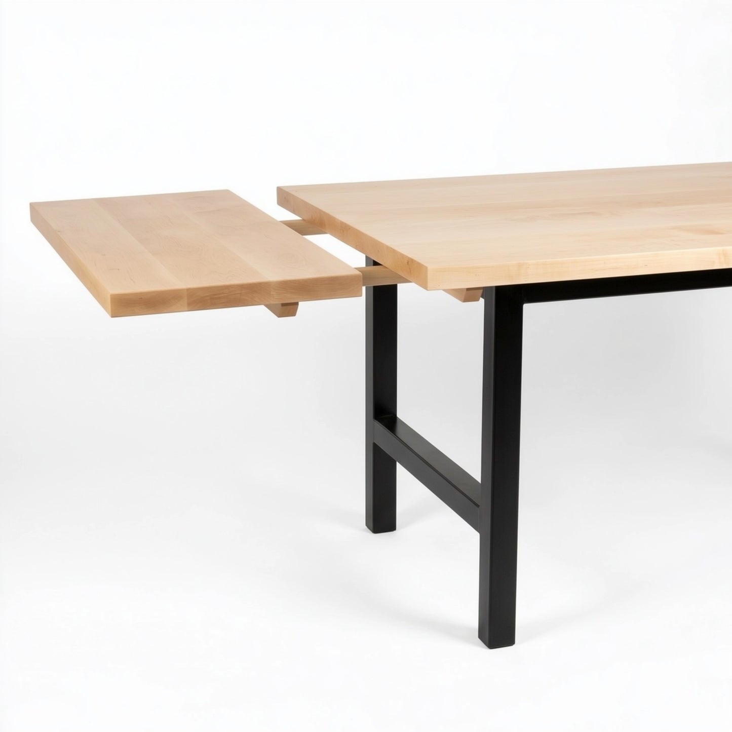 Wooden dining table with end extensions and black metal legs on a white background