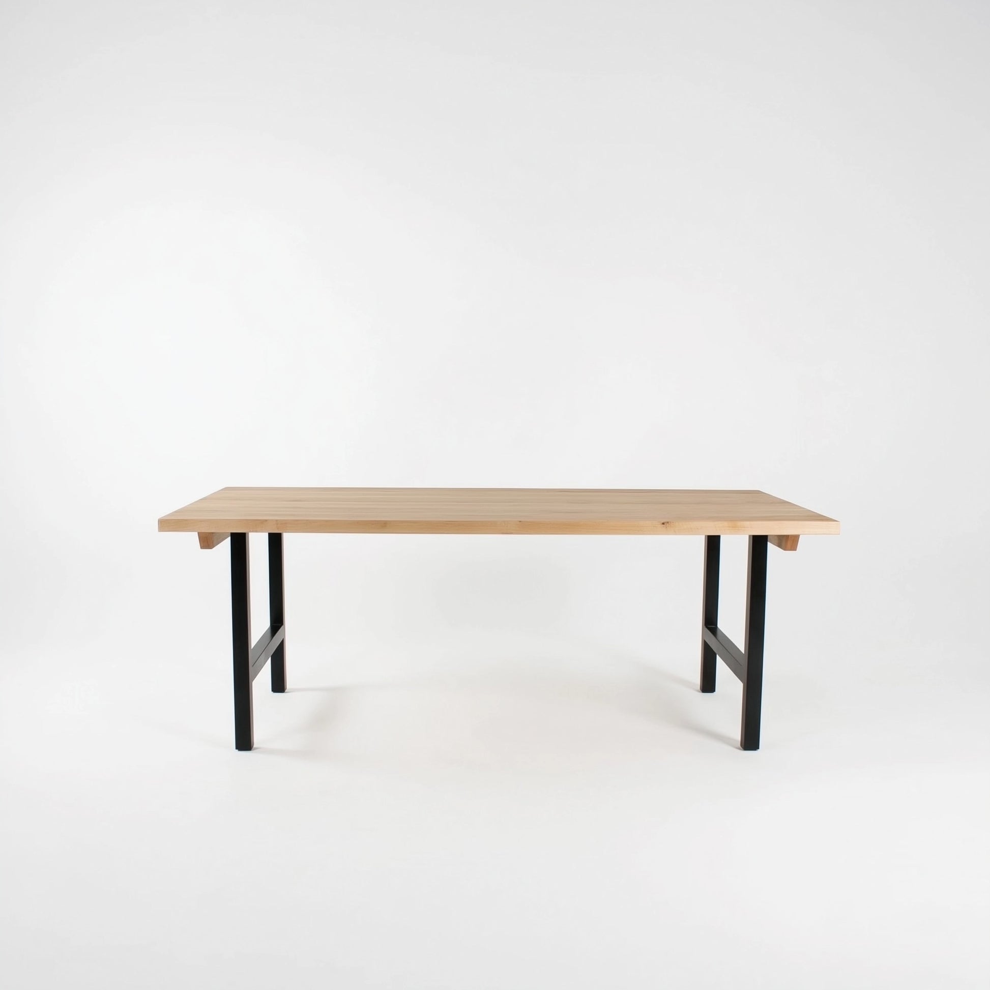 Wooden table with black legs on a white background