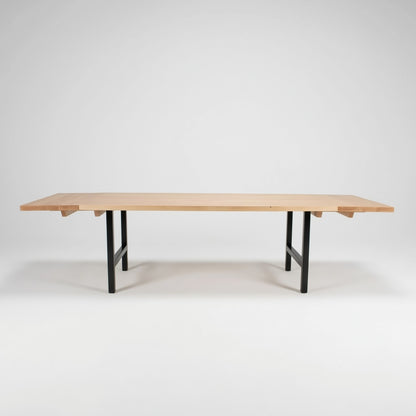 Wooden table with end extensions with black legs on a white background