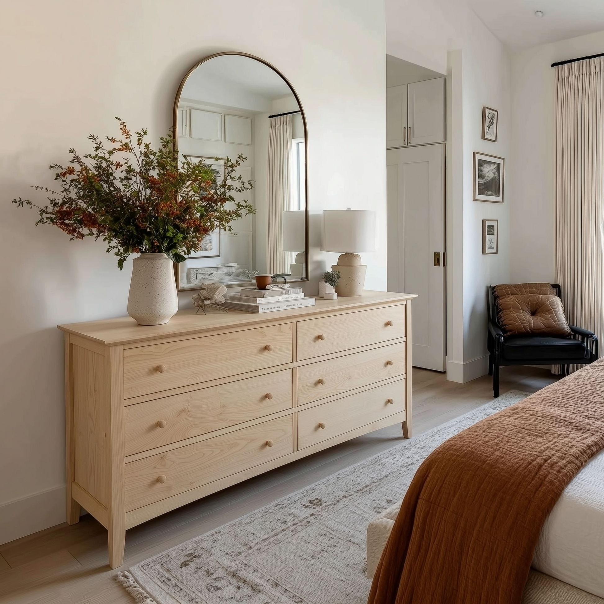 Wooden dresser in a bedroom with a mirror, lamp, and decorative items.