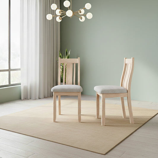 Two wooden chairs with gray cushions in a modern room with a light green wall and large window.