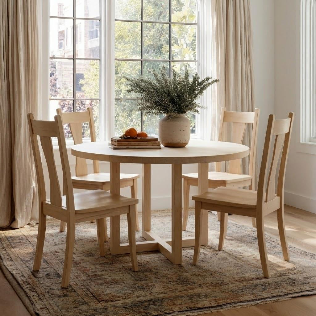 Dining room with wooden table and chairs near a large window.