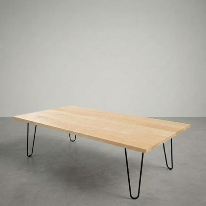 Wooden table with black hairpin legs on a gray floor and background