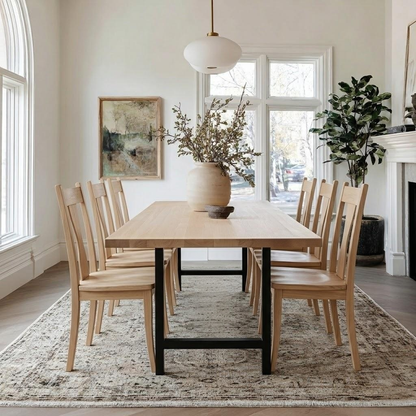 Dining room with wooden table and chairs, large windows, and decorative elements.