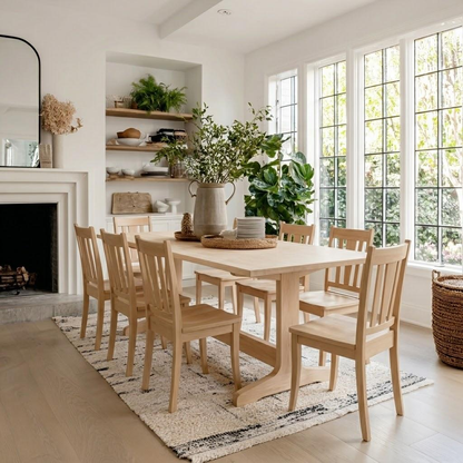 Dining room with wooden table and chairs, large windows, and a fireplace.