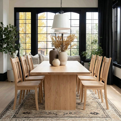 Dining room with wooden table and chairs, vase with flowers on the table.