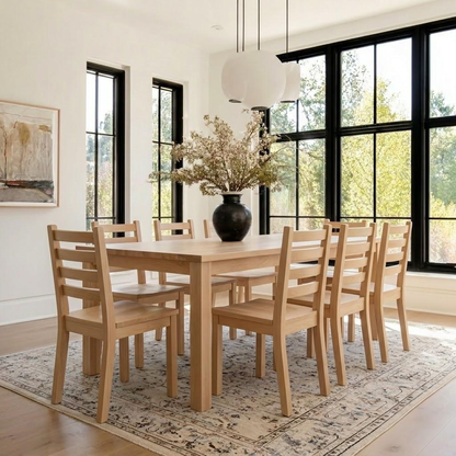 Dining room with wooden table and chairs, large windows, and a vase with flowers.