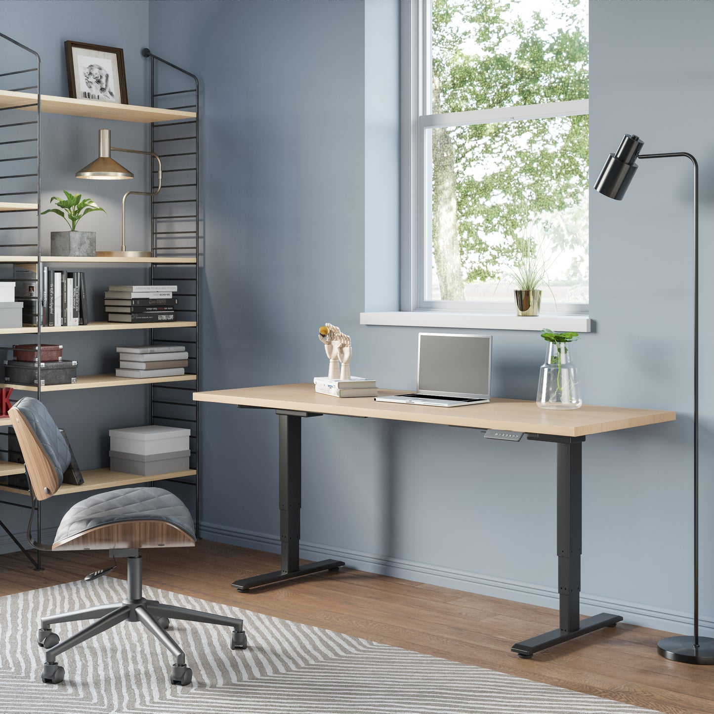 A standing desk made of maple in a home office with shelving and books