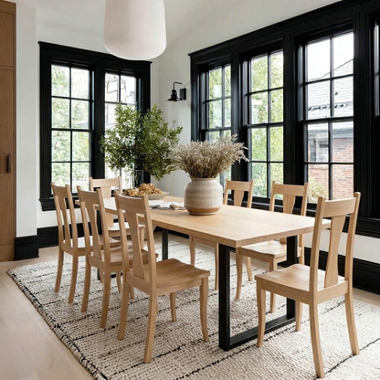 Dining room with wooden table and chairs, large windows, and decorative elements.