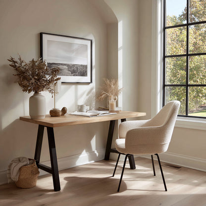 Home office with wooden desk, chair, and decorative elements near a window.