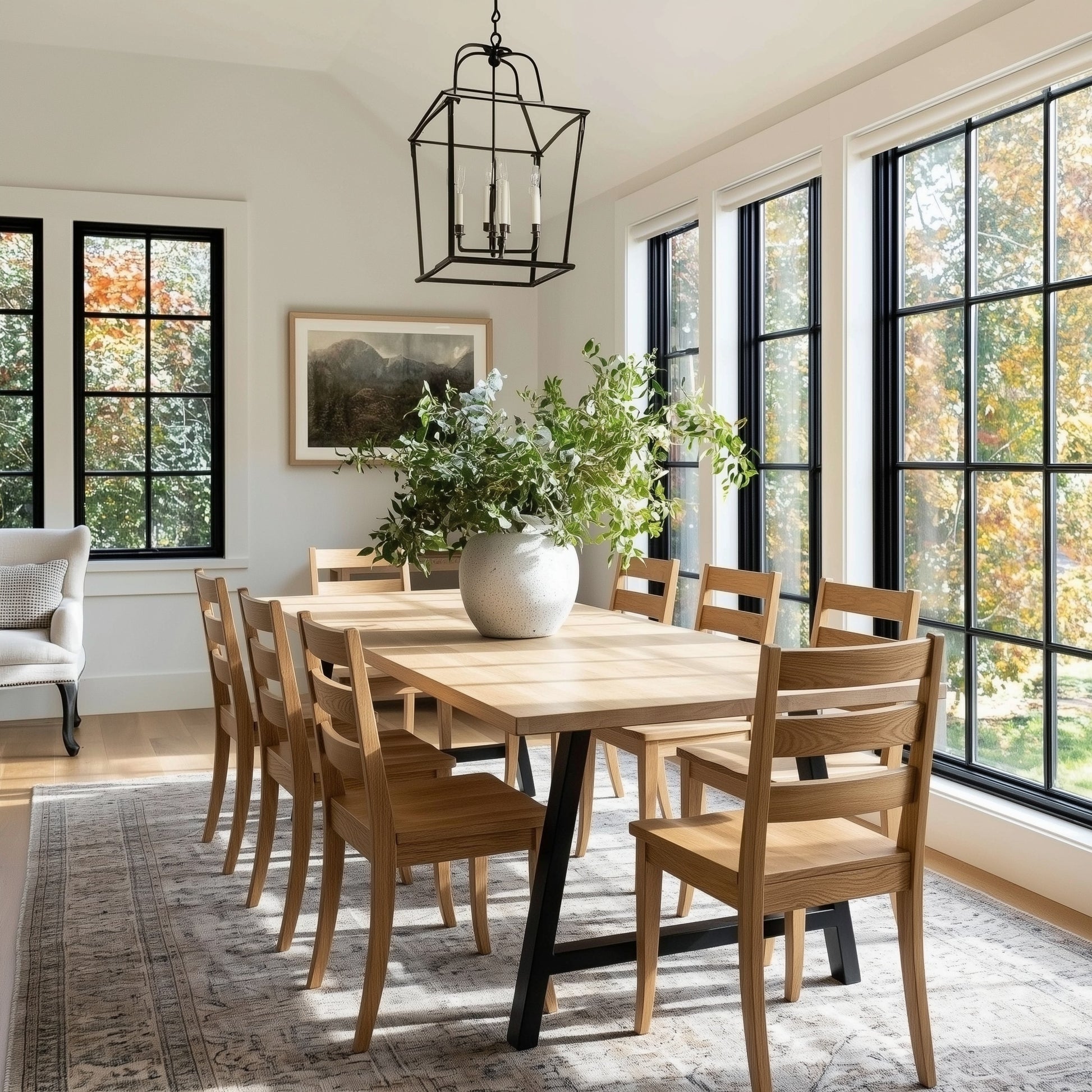Dining room with wooden table and chairs, large windows, and a rug.