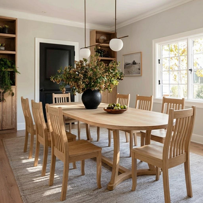 Dining room with wooden table and chairs, large vase of flowers, and a window.