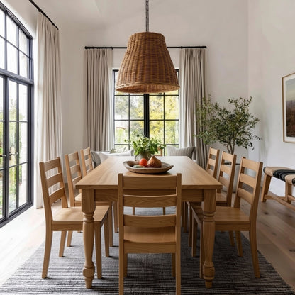 Dining room with wooden table and chairs, large window, and wicker pendant light.