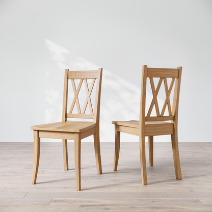 Two oak wood dining chairs with a 'Double X Back' design, placed against a neutral background.