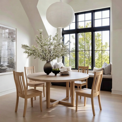 Dining room with wooden table and chairs, modern light fixture, and large plant on the table