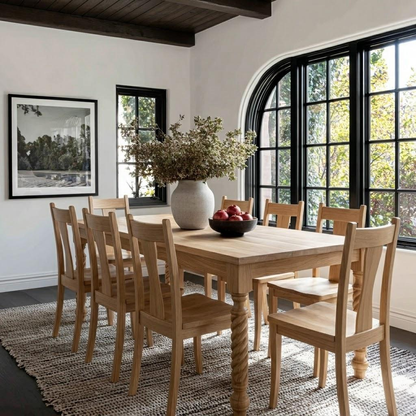 Dining room with wooden table and chairs, large window, and framed picture on wall.