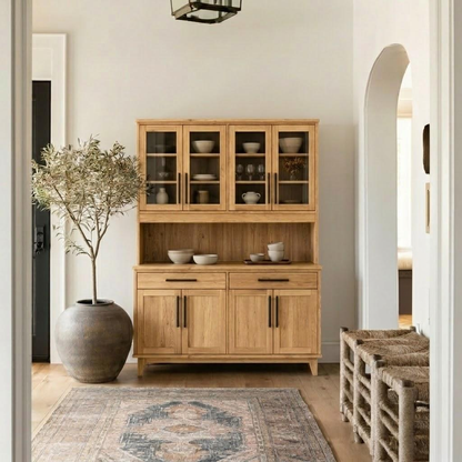 Wooden cabinet with glass doors in a room with a plant and rug.