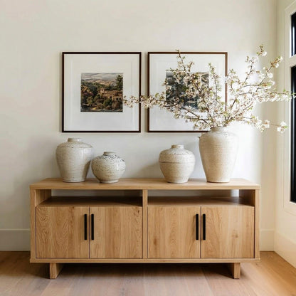Wooden sideboard with decorative items in a room with paintings on the wall.