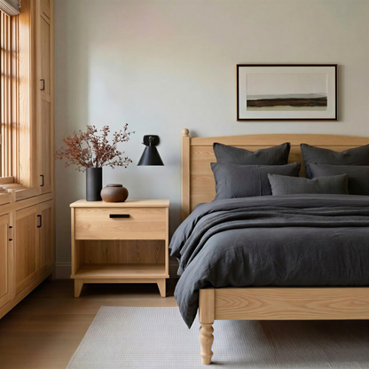 Modern bedroom with wooden bed and nightstand, gray bedding, and a framed picture on the wall.