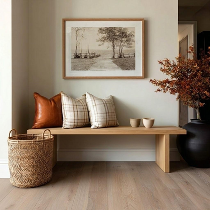 Nest living room with wooden bench, pillows, and decor items.