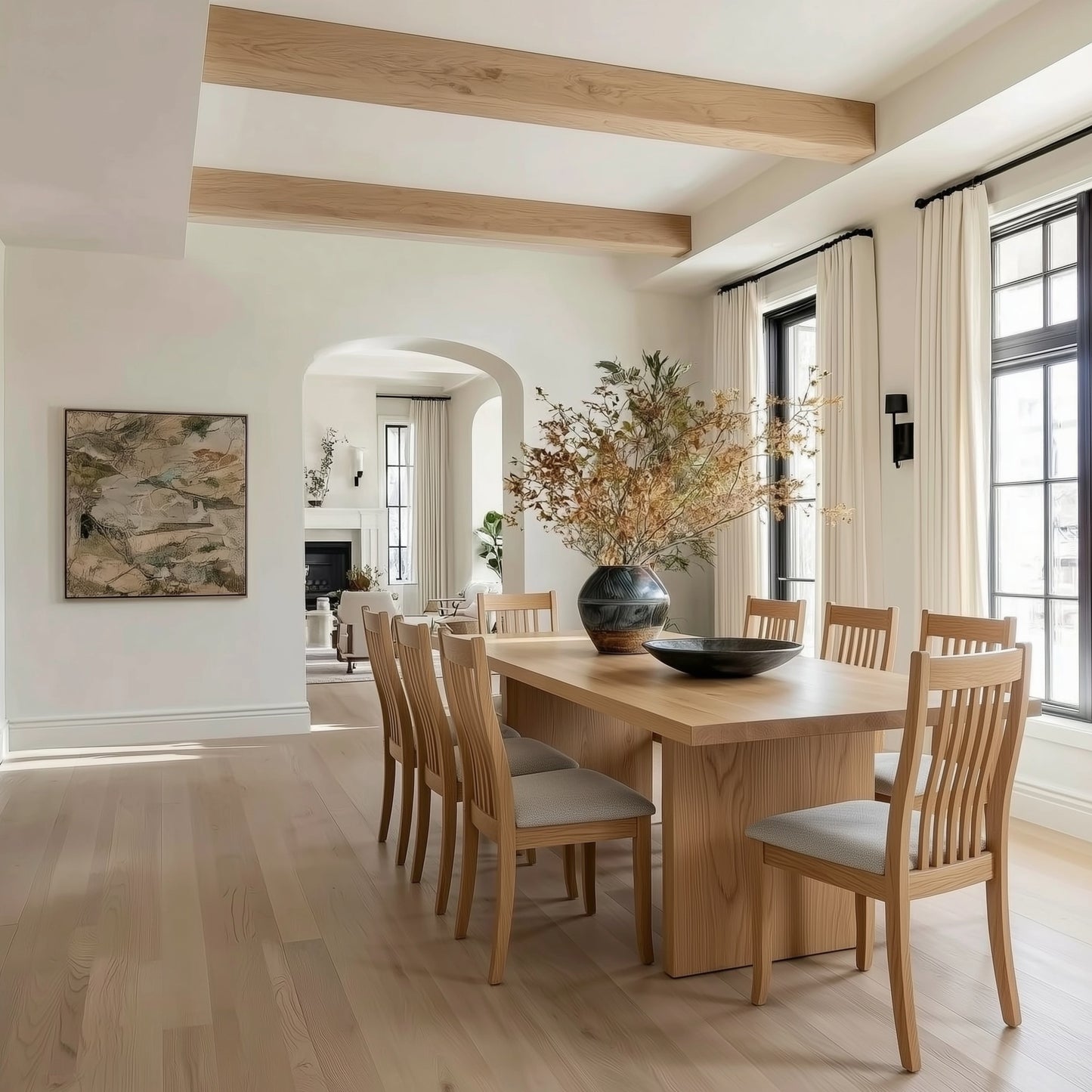 Dining room with wooden table and chairs, large windows, and decorative elements.